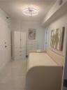 Room featuring large-format tile flooring and a circular flush-mount LED ceiling light fixture