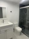 Bathroom featuring a vanity with a white composite countertop, integrated rectangular sink, and polished chrome faucet