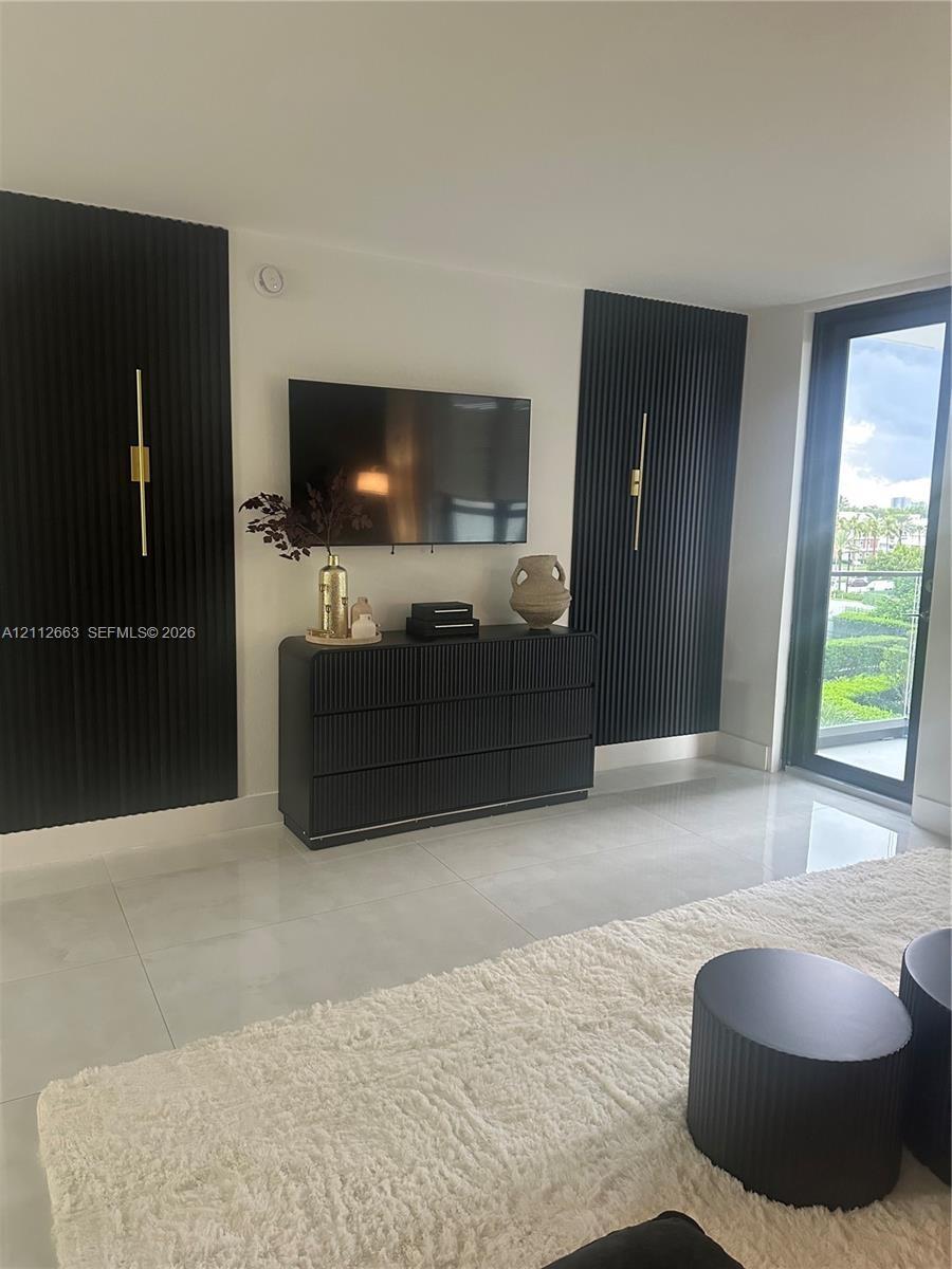 Large-format floor tile, black vertical slat feature wall accents, and slim metallic wall-mounted lighting fixtures