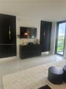 Large-format floor tile, black vertical slat feature wall accents, and slim metallic wall-mounted lighting fixtures