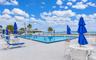 Outdoor swimming pool featuring a concrete deck and metal pool ladder