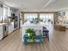 Kitchen featuring white shaker-style cabinetry, stainless steel appliances, a farmhouse sink, a central island with a solid surface countertop, and wo