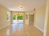 Ceramic tile flooring, arched wall openings, and sliding glass doors opening to a covered patio