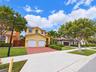 Stucco exterior residence featuring a two-car garage, paver driveway, and tiled roof