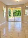 Tile flooring, sliding glass door, arched wall opening, and covered exterior patio with stone-finish pavers