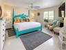 Room featuring neutral tile flooring, white plantation shutters, and a ceiling fan with leaf-style blades