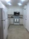 Kitchen featuring white cabinetry, solid-surface countertops, tile flooring, and stainless steel microwave and oven appliances