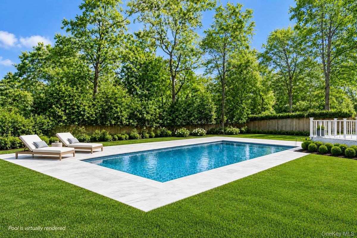 Rectangular inground pool with stone coping, expansive manicured lawn, perimeter fencing, and mature trees
