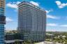 High-rise residential tower featuring a glass facade, floor-to-ceiling windows, and private exterior balconies on every level
