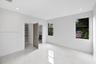 Interior space featuring polished porcelain tile flooring, recessed lighting, double-pane windows with black frames, and a walk-in closet with custom 