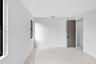 Interior space featuring large-format stone-finish tile flooring, neutral walls, recessed LED lighting, and a multi-panel door with matte black hardwa