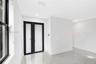 Neutral-toned tile flooring, recessed ceiling lighting, and double doors featuring frosted glass panels with matte black frames