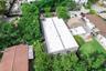 Aerial perspective featuring a flat roof structure surrounded by mature canopy trees and established landscaping