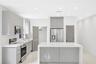 Contemporary kitchen featuring high-gloss cabinetry, a central island with a solid-surface countertop, stainless steel appliances, recessed ceiling li