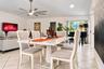 Open-concept interior featuring light-toned diagonal tile flooring, a multi-blade ceiling fan with integrated lighting, and glass sliding doors