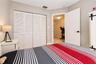 Room featuring four-panel louvered closet doors and a solid core interior door with matte black hardware