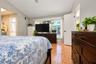 Vaulted ceiling with a central fan, ceramic tile flooring, and a large horizontal window providing exterior visibility