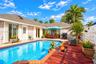 In-ground swimming pool with tile border, wood-finish decking, and privacy fencing