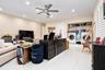 Large-format white tile flooring, recessed ceiling lighting, brushed metal ceiling fan, and built-in laundry area with overhead shelving