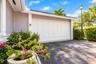 Exterior featuring horizontal siding, multi-panel garage door, attached wall-mounted light fixture, and paved driveway
