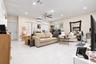 Living area featuring large-format tile flooring, recessed lighting, a ceiling fan, white louvered window shutters, and a wall-mounted ductless climat