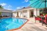 Outdoor living area featuring a swimming pool with tile trim, concrete patio surfacing, horizontal lap siding, and attached string lighting