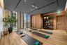 Fitness room featuring wood-finish flooring, wood-paneled walls, floor-to-ceiling slatted privacy screens, and a recessed ceiling with integrated line