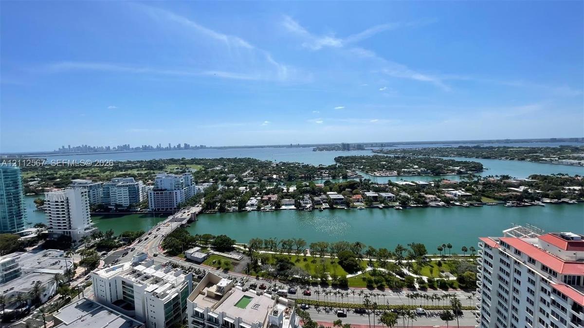 Elevated perspective featuring expansive water frontage, bridges, cityscape skyline, and surrounding coastal landscape