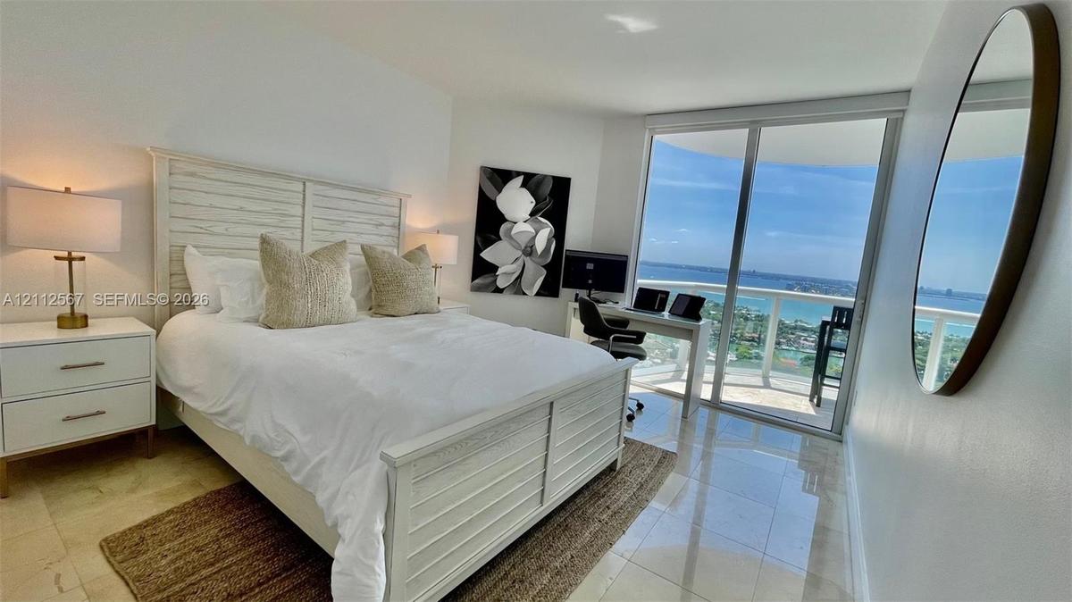 Polished stone flooring, floor-to-ceiling sliding glass doors, and a private balcony