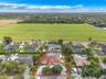 Single-story residence featuring a tile roof, circular driveway, swimming pool, and mature perimeter landscaping