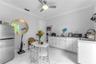 Kitchen featuring white shaker-style cabinetry, solid-surface countertops, large-format tile flooring, a stainless steel refrigerator, and a ceiling-m