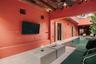 Open-air courtyard featuring a private pool, exposed timber ceiling beams, textured terracotta-toned walls, and stone-finish flooring