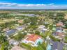 Aerial perspective featuring a residence with a clay tile roof, concrete driveway, and in-ground swimming pool