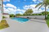 Outdoor swimming pool with integrated spa, concrete decking, and privacy fencing