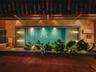 Indoor swimming pool with tiered entry steps, natural stone wall cladding, built-in recessed lighting, and integrated planters