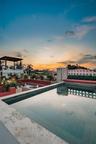 Rooftop terrace featuring a stone-lined pool, built-in masonry seating, a pergola, and decorative open-patterned privacy screening