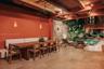 Covered patio featuring exposed wood-beam ceilings, stone masonry wall accents, neutral-toned tile flooring, and an integrated swimming pool