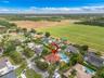 Aerial view of residential property featuring a clay tile roof, a private swimming pool, and a paved circular driveway
