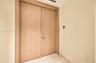 Double-door entry featuring light wood-finish slab doors with matching door casing and metallic hardware