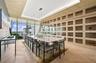 Floor-to-ceiling built-in cabinetry with integrated rolling library ladder, wood-finish herringbone flooring, recessed tray ceiling, modern linear pen