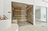 Custom sauna featuring wood-panelled interior, multi-level bench seating, and glass enclosure, paired with a glass-enclosed steam shower featuring neu