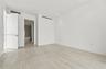 Large-format tile flooring, recessed ceiling lighting, and solid-core doors