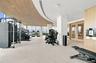 Fitness center featuring floor-to-ceiling windows, slatted wood-finish ceiling, recessed lighting, and wall-mounted water dispenser
