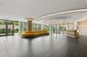 Lobby featuring large-format dark stone flooring, floor-to-ceiling glass walls, recessed cove lighting, and a circular chandelier