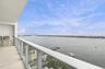 Covered balcony featuring a glass railing, tiled flooring, and a built-in stainless steel outdoor kitchen station