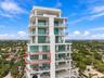 High-rise residential exterior featuring glass-railed private balconies, floor-to-ceiling windows, and integrated outdoor kitchen fixtures