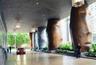 Covered porte-cochere featuring monumental sculptural columns, paved driveway, recessed ceiling lighting, and hanging pendant fixtures