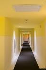 Hallway featuring two-tone wall paint, recessed ceiling lighting, a flush-mount overhead HVAC unit, integrated fire safety components, and dark wall-t