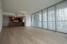 Open-concept interior featuring floor-to-ceiling glass wall panels, wood-finish flooring, and a kitchen equipped with built-in stainless steel applian