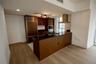 Kitchen featuring wood-finish cabinetry, dark stone countertops, stainless steel appliances including a built-in refrigerator and wall oven, and a cen